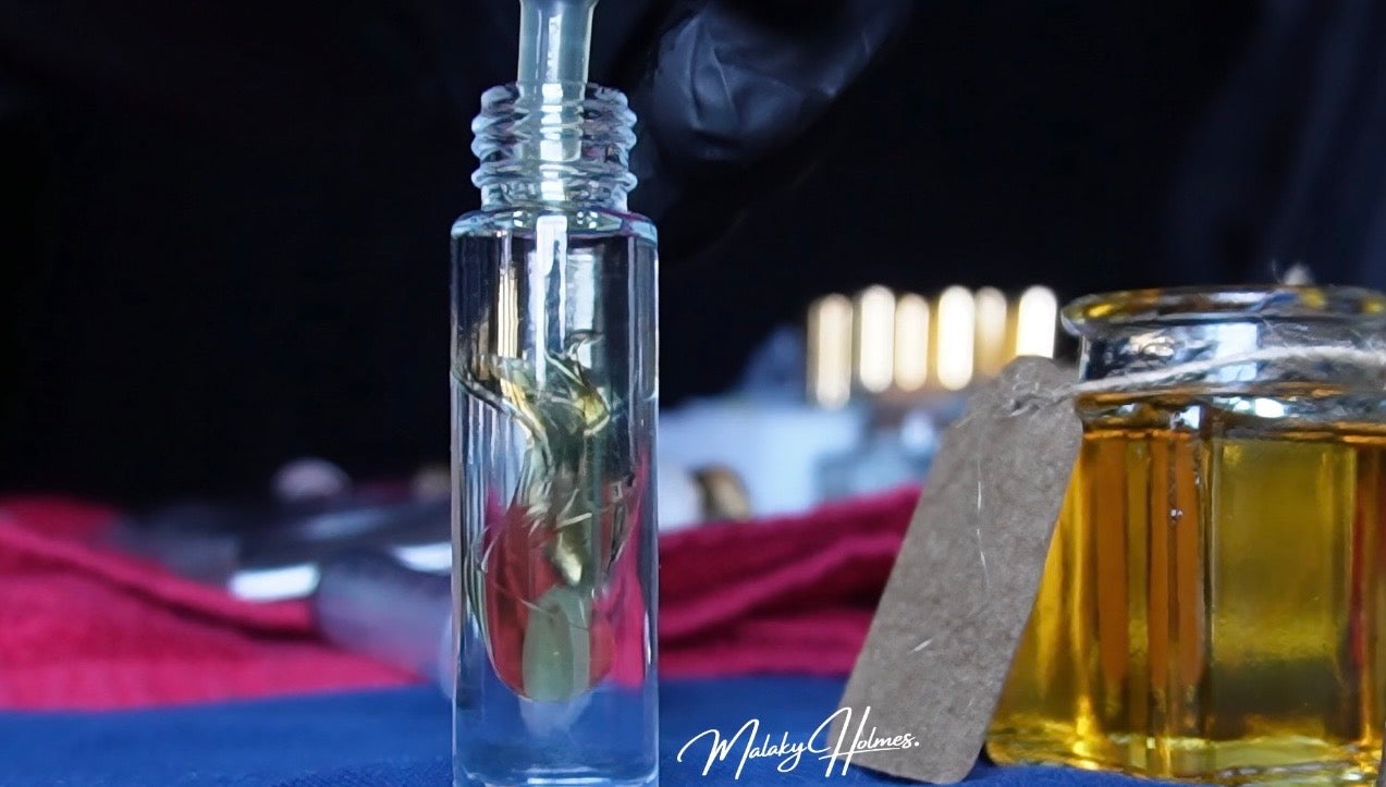 Load video: Close-up video of a Malaky Holmes fragrance concentrate dispersing into a clear oil carrier, forming swirling ribbons as the formula blends smoothly inside a glass bottle on a clean studio surface.
